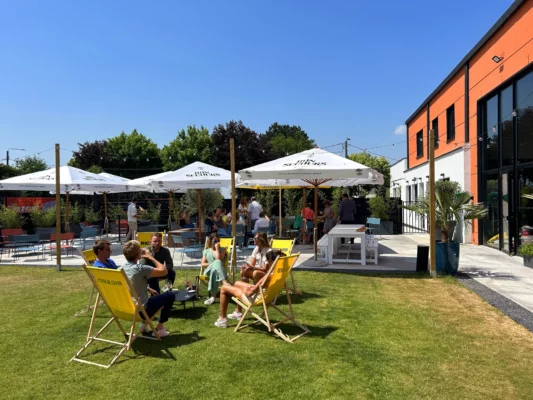 Photo de personnes buvant un verre dans les transats sur la terrasse du KHUB Arras karting. Bar terrasse